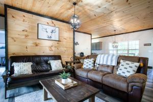 ein Wohnzimmer mit Ledermöbeln und Holzwänden in der Unterkunft Pine Cove Cabin - Hot Tub, Game Room, Theater Room in Pigeon Forge