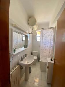 uma casa de banho branca com um lavatório e um WC em Chill Place em Anavissos