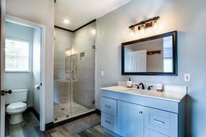 ein Badezimmer mit Waschbecken und Dusche mit Spiegel in der Unterkunft Pine Cove Cabin - Hot Tub, Game Room, Theater Room in Pigeon Forge + 42 Fotos