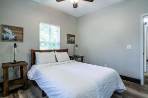 ein Schlafzimmer mit einem weißen Bett und einem Fenster in der Unterkunft Pine Cove Cabin - Hot Tub, Game Room, Theater Room in Pigeon Forge