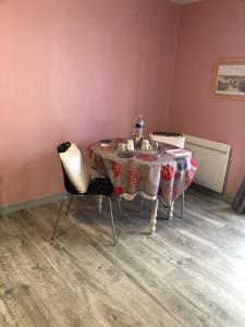 mesa de comedor con mesa y 2 sillas en Les chambres du Moulin, en Les Epsailles