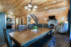 a dining room and living room with a wooden table at Bandit Lodge BRAND NEW CABIN w Pool in Sevierville