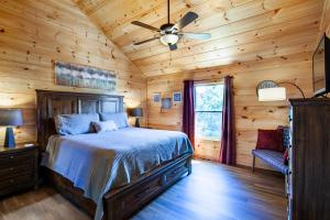 a bedroom with a bed and a ceiling fan at Bandit Lodge BRAND NEW CABIN w Pool in Sevierville +43 photos
