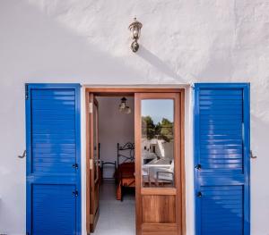 a room with blue doors and a bedroom at Bungalows Es Pins - Emar Hotels in Playa Migjorn +76 photos