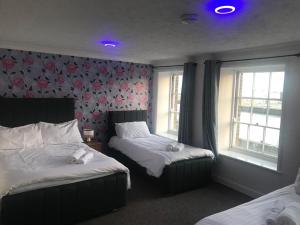 um quarto com 2 camas e 2 janelas em Spacious One Bedroom Flat with River View, 1E em Great Yarmouth