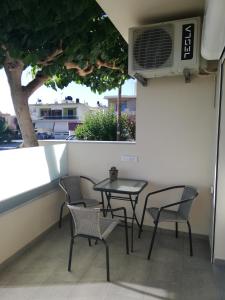 un tavolo e sedie su un balcone con finestra di Anna's Home a Kíssamos