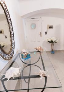 a glass table with starfish and a mirror at Casa Vacanza Verde Smeraldo- (San Montano) in Massa Lubrense