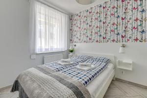 a bedroom with a bed with a blue and white blanket at Apartamenty PIAMOLA Bursztynowe Osiedle Jantar in Jantar