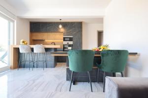 Una cocina con encimera y sillas verdes. en Rhapsody in Green - Luxury villa in Zadar, en Crno