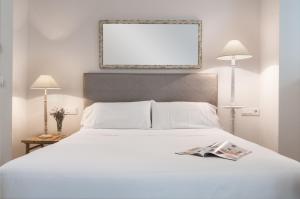Łóżko lub łóżka w pokoju w obiekcie Suites Sevilla Plaza