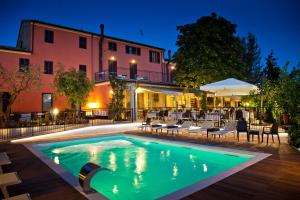a pool in front of a building at night at Hotel La Palomba in Mondavio