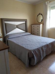 a bedroom with a bed and a mirror and a dresser at Irene Beach Málaga, Parking Gratuito in Cala del Moral