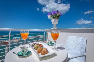 una mesa con un plato de comida y dos vasos de zumo de naranja en Hibrido Boutique Hotel & Spa, en Sciacca