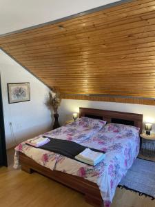 sypialnia z dużym łóżkiem i drewnianym sufitem w obiekcie Kuća za odmor ZIVA - Bjelovar w mieście Veliko Trojstvo