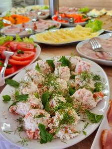 un plato blanco de comida en una mesa con verduras en Tasarz Spa Ośrodek Wczasowy en Rewal