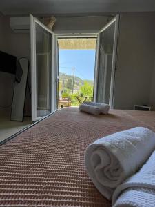 a bedroom with a large bed with a large window at Apricus Apartments in Apolpaina