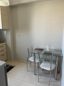 Apricus Apartments في Apolpaina: غرفة طعام مع طاولة وكراسي