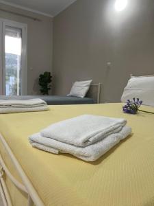 two white towels sitting on top of a bed at Apricus Apartments in Apolpaina