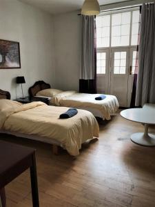a room with three beds and a table at Guesthouse Copenhagen in Copenhagen
