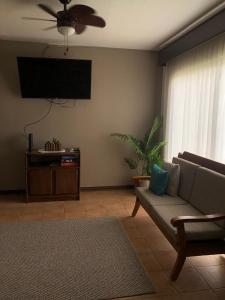 a living room with a couch and a ceiling fan at Apartamento Chorotega in Liberia