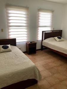 sypialnia z 2 łóżkami i 2 oknami w obiekcie Apartamento Chorotega w mieście Liberia