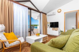 un soggiorno con un divano e un tavolo di Villa Paradiso a Punat