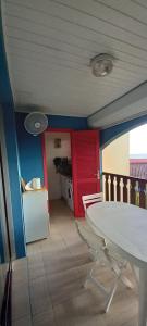 una sala da pranzo con tavolo bianco e una cucina di BO SOLEY, studio vue mer Les Hauts de Caritan a Sainte-Anne