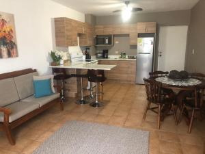 eine Küche und ein Wohnzimmer mit einem Sofa und einem Tisch in der Unterkunft Apartamento Chorotega in Liberia