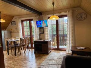 a kitchen and dining room with a table and a television at Apartamenty i pokoje Domino in Karpacz