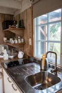 a kitchen with a stainless steel sink and a window at de Bieslandse Heerlijkheid in Delft