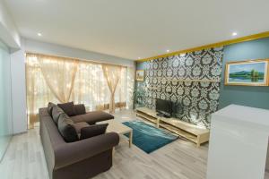 - un salon avec un canapé et une télévision dans l'établissement Aparthotel Jolie, à Galaţi