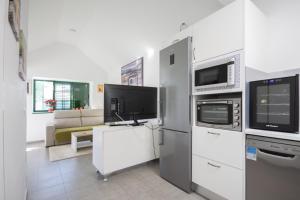 a living room with a tv and a microwave at Charming bungalow with private garden in Maspalomas