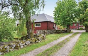 une grange rouge avec un chemin de terre devant elle dans l'établissement Cozy Apartment In Tjrnarp With House A Panoramic View, à Tjörnarp