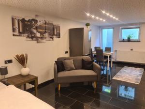 a living room with a couch a chair and a table at Appartement am Ziegeleipark in Heilbronn