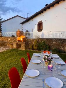 uma mesa com pratos e copos de vinho num quintal em Casa Rural El Trineo de Campoo - Alto Campoo em Suano