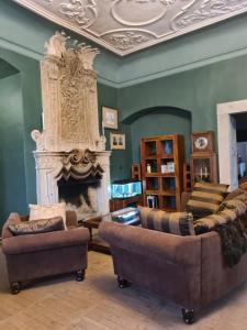 a living room with two chairs and a fireplace at Pałac Rząsiny in Gryfów Śląski