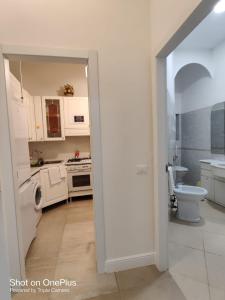 a white kitchen with a sink and a toilet at Grand Cucinetta in Rome