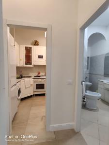 a white kitchen with a sink and a toilet at Grand Cucinetta in Rome