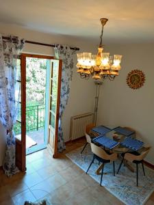 a dining room with a table and a chandelier at Casabonsai in Fivizzano