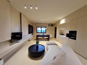 Ammos ikia في أورانوبوليس: غرفة معيشة مع أريكة بيضاء وطاولة