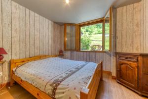 een slaapkamer met een houten bed en een raam bij La Grange de St Même in Saint-Même