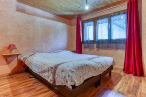 Schlafzimmer mit einem Bett mit roten Vorhängen in der Unterkunft La Grange de St Même in Saint-Même