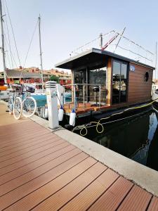 La Maison Bateau Sotogrande في سان روكي: قارب مرسى على رصيف مع الدراجات متوقفة بجواره