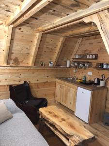 een keuken in een blokhut met een koelkast en een tafel bij Cottage Bumblebee in Žabljak