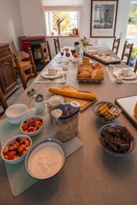 B&B l'Aigrin في دربي: طاولة مليئة بالأطباق وأوعية الطعام