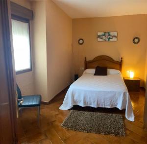 a bedroom with a bed and a window and a chair at Casa A Illa de Arousa in Isla de Arosa