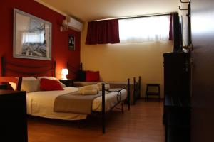 Schlafzimmer mit roten Wänden, einem Bett und einem Fenster in der Unterkunft i Santuzzi BeB in Lentini