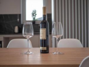 una bottiglia di vino seduta su un tavolo con due bicchieri da vino di Lovely Partial Sea View one bedroom flat in Horizon Residences A22 a Bečići