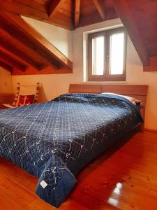 una camera da letto con un letto con un piumone blu e una finestra di Green Marble Pool Cottage 3 BR in 2 adjoining stone buildings on a 2 acre private land a Viganj Altre 36 foto