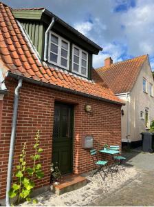 une maison en briques avec une porte verte et une table dans l'établissement Færgestræde 45, à Marstal